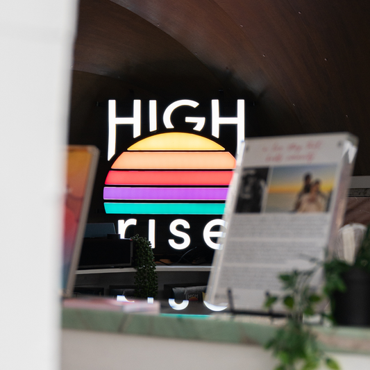 High Rise neon LED sign, at the back of a bar, lighting up the room
