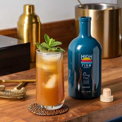 Black Tea Mocktail on wooden bar with High Rise 10mg Orange Infusion Bottle 