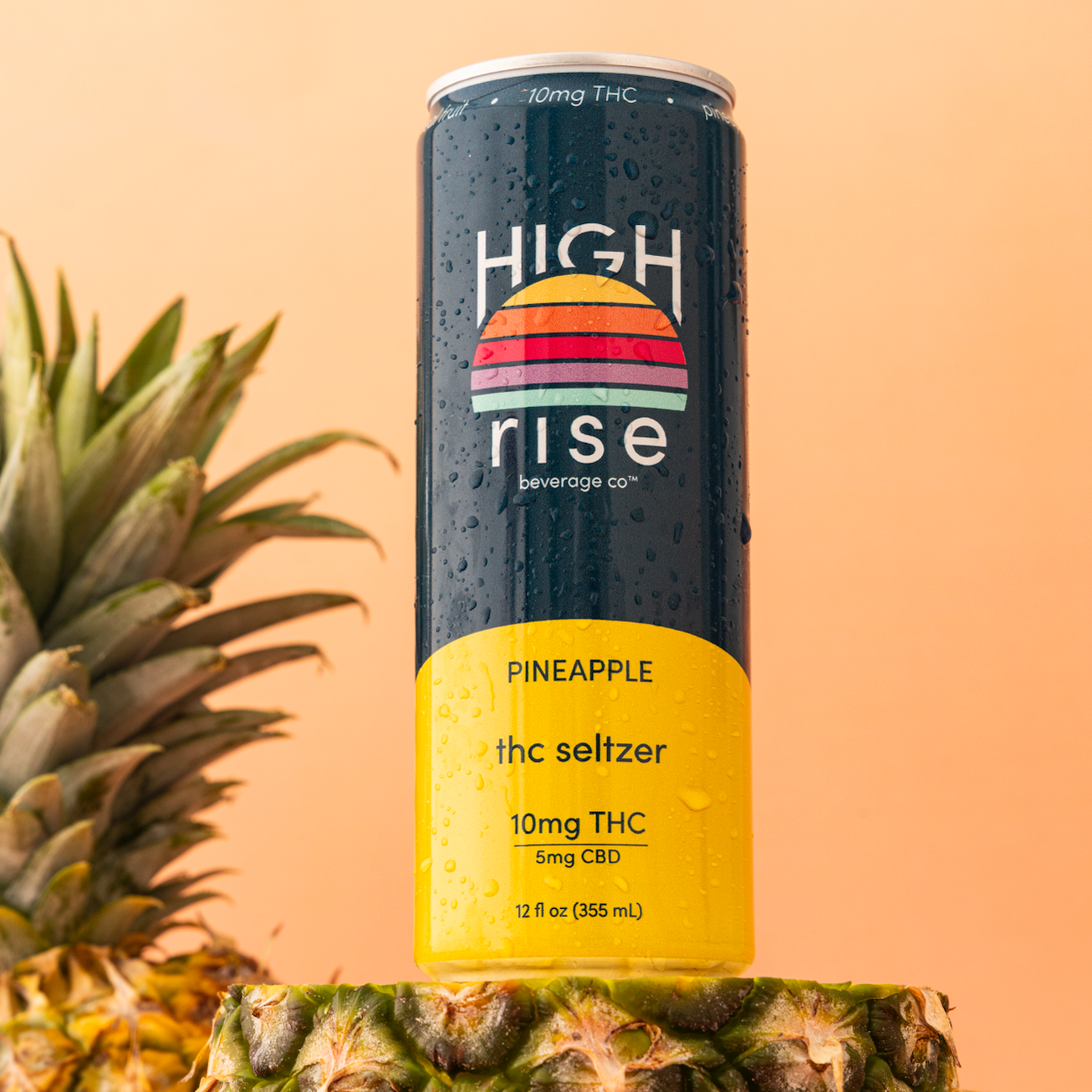 Canned High Rise Pineapple 10mg THC-seltzer with pineapples in background on a peach background