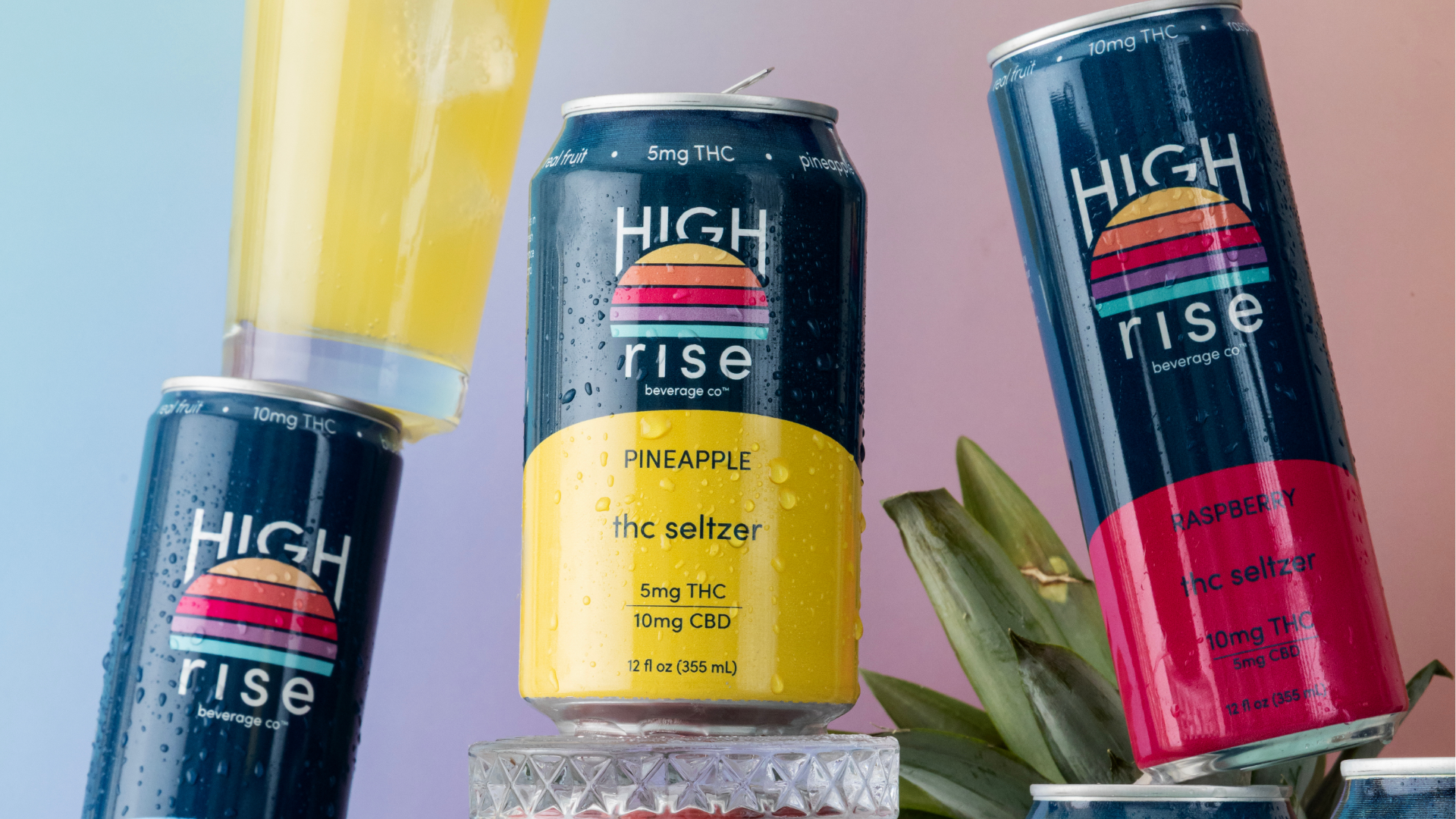 high rise stylized hero image, featuring pineapple 5mg thc seltzer and raspberry 10mg thc seltzer, both in 12oz cans