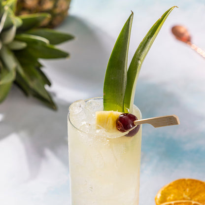 High Rise THC mocktail with pineapple garnish on a light surface.